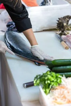 The salmon is in the hands of the experienced chef. Stock Photos