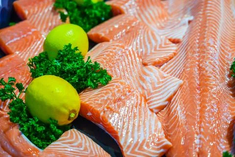 Salmon roasted portion of cooked fish and fresh lemon on the store counter Stock Photos