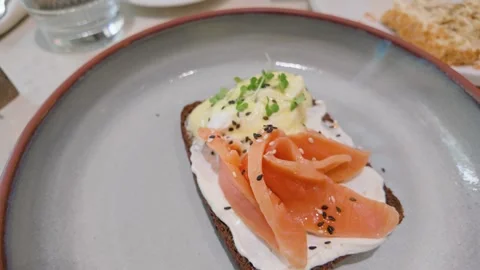 Salmon rye toast on restaurant table with water glass Stock Footage 346289873