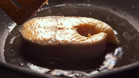 Salmon steak is cooked in a frying pan in close-up Stock Footage 277968963