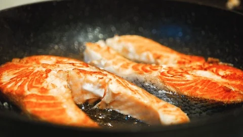 Salmon steak fillet cooking process on a frying pan. Macro shot of healthy food Stock Footage 107533385