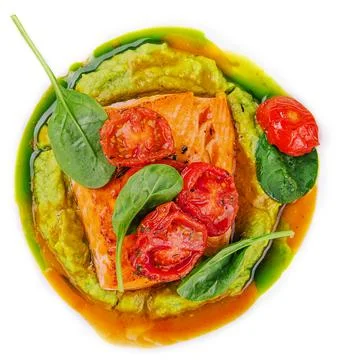 Salmon steak with mashed avocado, decorated with basil leaves and cherry to.. Foto stock