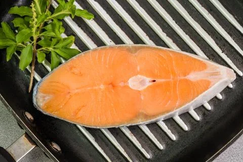 Salmon steak on pan Stock Photos