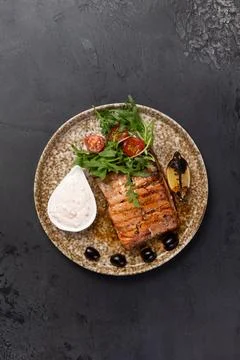 Salmon steak in a plate. On a dark background. Stock Photos