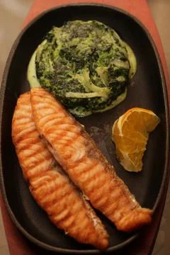 Salmon steak served with spinach Stock Photos