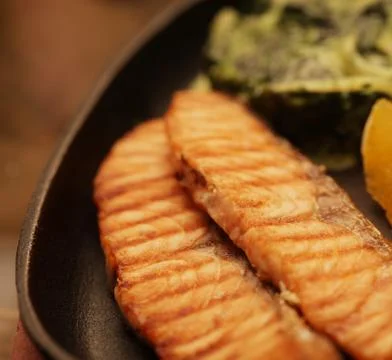 Salmon steak served with spinach Stock Photos