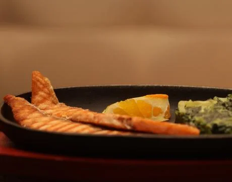 Salmon steak served with spinach Stock Photos