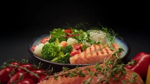 Salmon steak with vegetables. On a dark background. Stock Footage 300465652