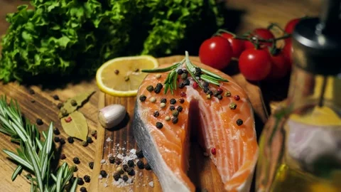 Salmon steak.Red fish steak from raw trout with herbs, lemon and olive oil Stock Footage 198888631