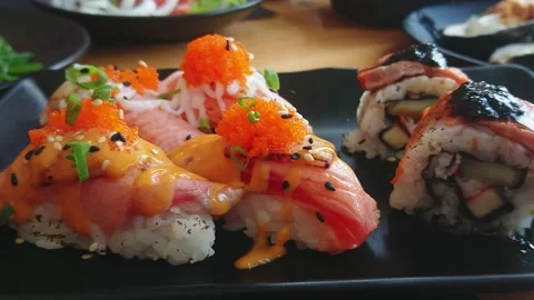 Salmon sushi set in black ceramic disk. Japanese cuisine. Panning right. Stock Footage 140458144