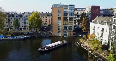 Salon barge passing balconied flats on a sunlit canal Vidéo 71293912