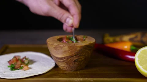 Salsa being put on a tortilla Stock Footage 243486376