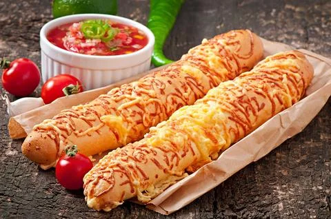 Salsa dip in bowl of bread and cheese sticks on wooden background Stock Photos
