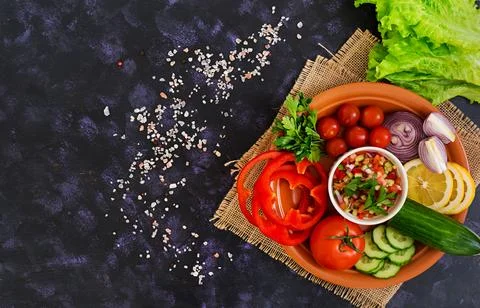 Salsa with ingredients on dark background. Top view Stock Photos