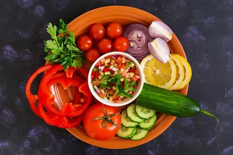 Salsa with ingredients on dark background. Top view Stock Photos