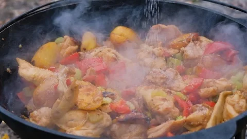 Salt is added to the dish in the cauldron, slow motion. Frame of adding salt to Stock Footage 279271758