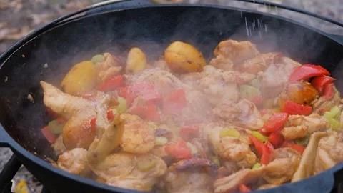 Salt is added to the dish in the cauldron, slow motion. Frame of adding salt to Stock Footage 284173886
