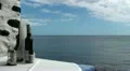Salt and pepper shakers and red wine in glass bottle on sea background HD Footage