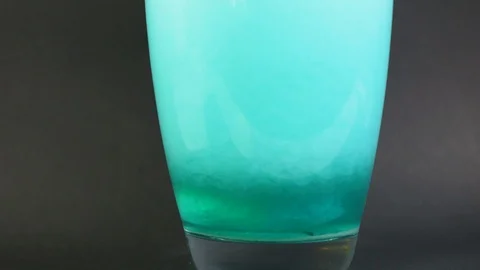 Salt bath dissolves in a vase of water in slowmotion with particle drilling 4K Stock Footage 119540843