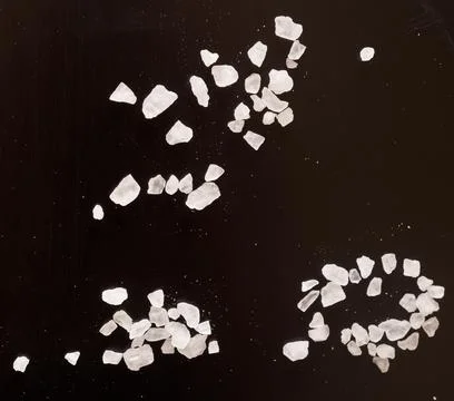 Salt on black Stock Photos