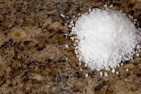 Salt on a brown marble background. Stock Photos