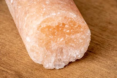Salt crystal drill probe containing minerals causing its pink color on wooden Stock Photos