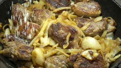Salt drops in slow motion of meat with onions. Stock Footage 129291152