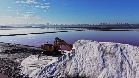 Salt extraction process near a city with a loader and salt piles Stock Footage 328528008