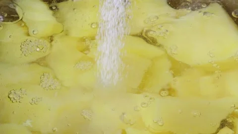 Salt falling on boiling potatoes in water. Slow Motion. Stock Footage 305434180