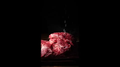 Salt Falling on Raw Meat against Black Background Stock Footage 334909323