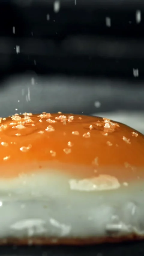 Salt falls on the fried egg. Filmed on a high-speed camera at 1000 fps Stock Footage 335384706