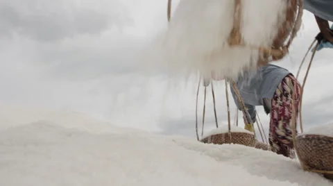 Salt field workers scale a mountain of salt  Stock Footage 42424498