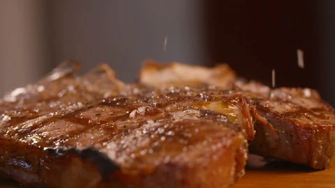 Salt flakes being sprinkled on the cooked meat Stock Footage 86171303