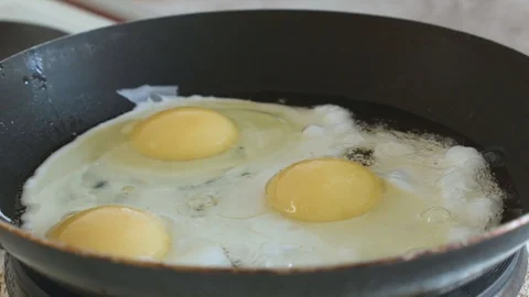 Salt fried eggs in a pan slowmotion Stock Footage 108000308