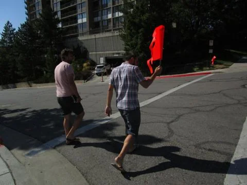 Salt Lake City, USA - 08 18 2017: Two pedestians crossing the street signaling Stock Photos