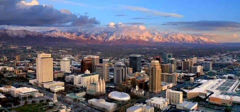 Salt Lake City Utah Skyline at Sunset, Mountains Behind, Aerial Drone Stock Footage