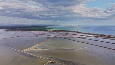 Salt mining operation near the coast with vast salt flats visible Stock Footage 335140970