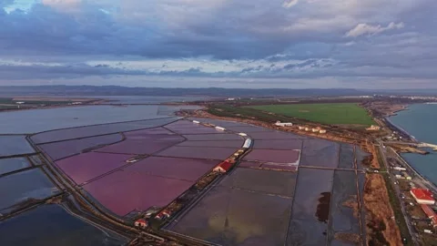 Salt pans under cloudy sky near the coast with fields in the background Vídeos de archivo 335142298