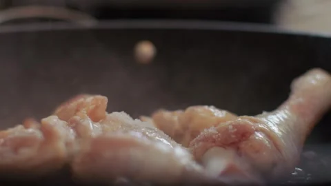 Salt is poured onto the chicken leg. Add salt to the dish to make the chicken Stock Footage 255841653