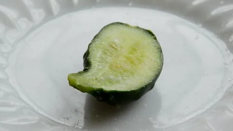 Salt is poured onto a cucumber Stock Footage 259306067
