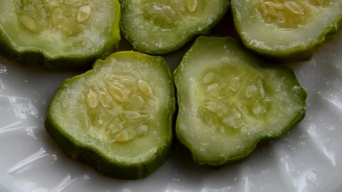 Salt is poured onto a cucumber Stock Footage 271449636