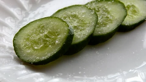 Salt is poured onto a cucumber Stock Footage 271481447