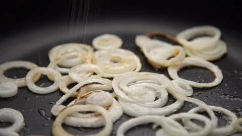 Salt is poured on the fried onion Stock Footage 158543046