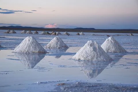 Salt pyramids reflecting in a flat salt lake Stock Photos