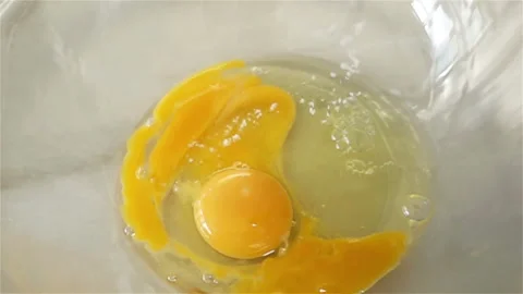 Salt Raw Egg Falling on Glass Bowl in Slow Motion Stock Footage 129261739