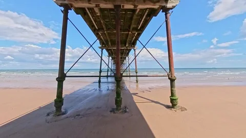 Saltburn beach captured from under the pier on a bright and sunny day Stock-Footage 245807618