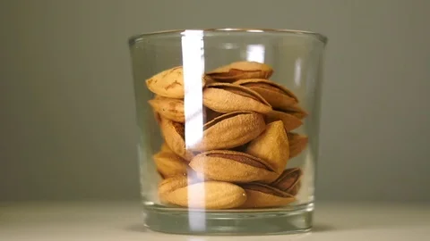 Salted almonds in shells in transparent glass with white reflection Stock Footage 75241513