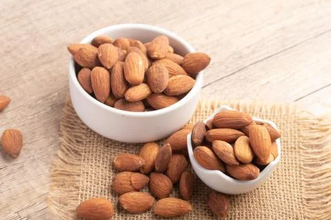 Salted almonds in a white cup.Copy space. Stock Photos