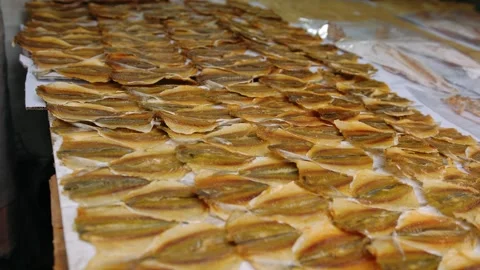 Salted and dried fish fillets displayed at a traditional street market stal.. Video stock 336984956
