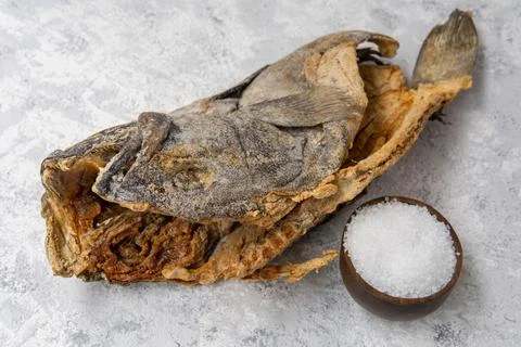 Salted cod with sea salt on a light background Stock Photos